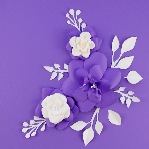 Arreglo plano con flores de papel y fondo morado