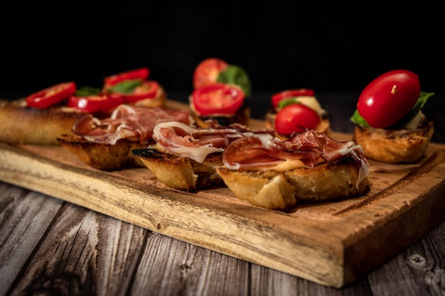 Arreglo de una selección de diferentes tapas o bruschettas en una tabla de madera Concepto de comida mediterránea