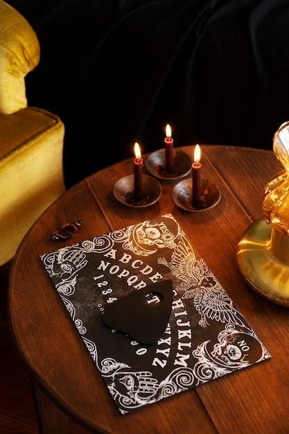 Foto arreglo de tabla ouija y velas encendidas