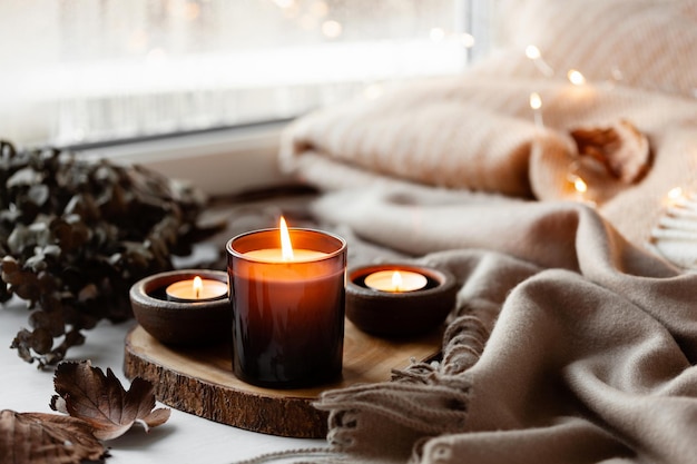 Arreglo de ventana cálido y acogedor concepto de invierno u otoño velas arrojar luces
