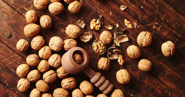 Desde arriba disparo de cascanueces de madera y un montón de nueces frescas que se encuentran en la superficie rasgada de la mesa de madera