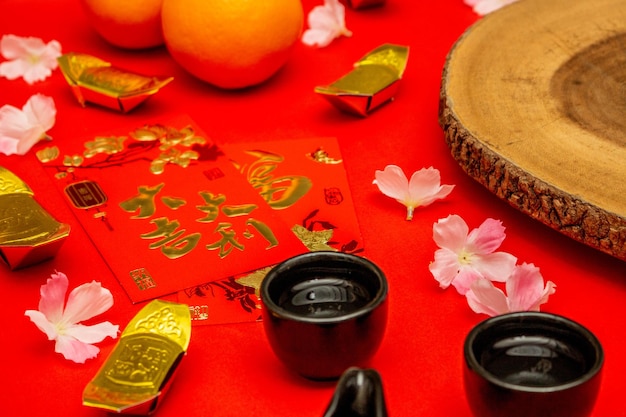 Arriba, vea los accesorios del año nuevo chino o el festival del día del humor, naranjas doradas y bolsillos de Angpao con decoraciones de ramas de cerezos en flor.