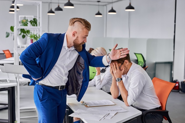 Arroganter Direktor der Firma schimpft Mann für schlechte Arbeit und wird ihn von der Arbeit entlassen. Im Büro zeigt der bärtige Direktor auf die Tür, der Angestellte weint