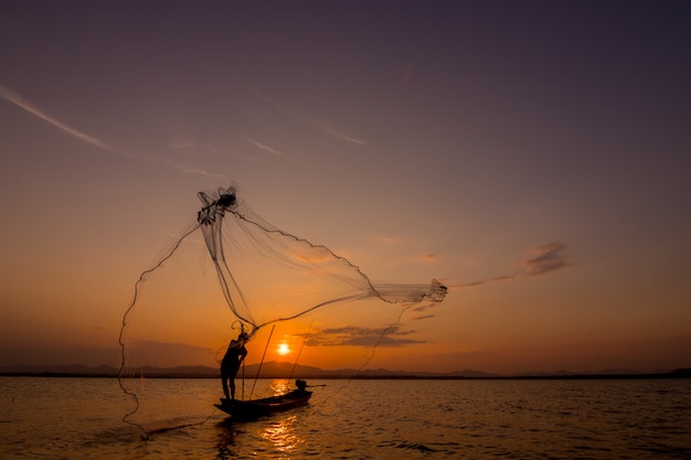 arrojando red de pesca durante el atardecer