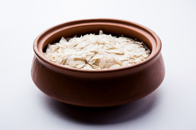 Arroz achatado cru ou flocos de arroz grossos ou finos para lanches Namkeen Chivda ou Aloo Poha para café da manhã indiano, servido em uma tigela