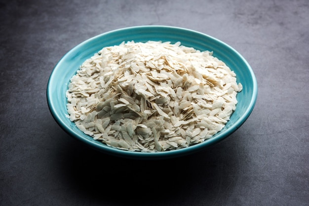 Foto arroz achatado cru ou flocos de arroz grossos ou finos para lanches namkeen chivda ou aloo poha para café da manhã indiano, servido em uma tigela