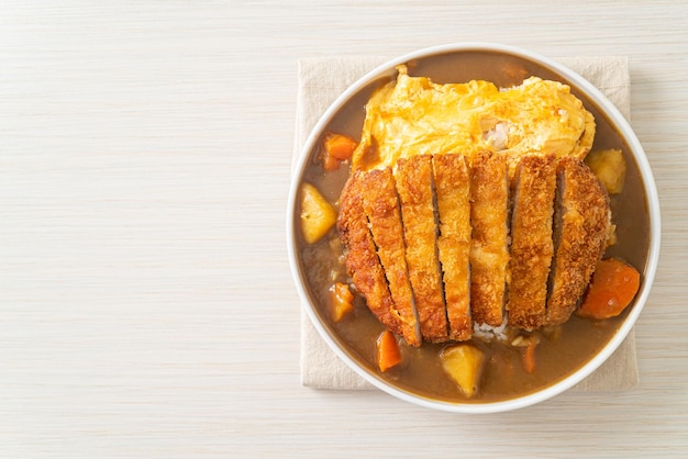 Arroz al curry con chuleta de cerdo frita tonkatsu y tortilla cremosa - estilo de comida japonesa