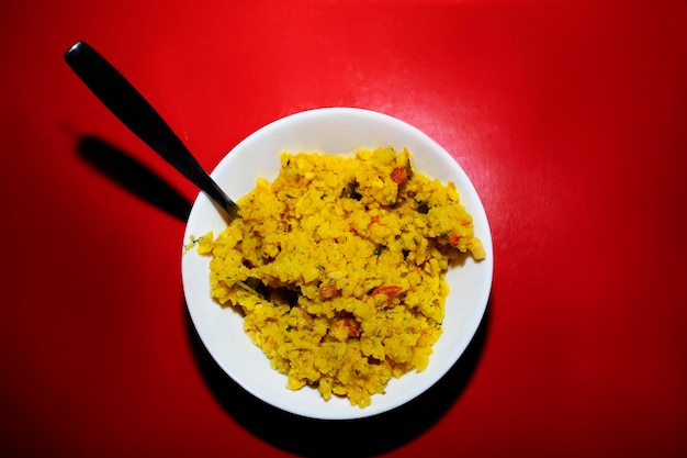 Arroz amarillo en plato sobre mesa roja