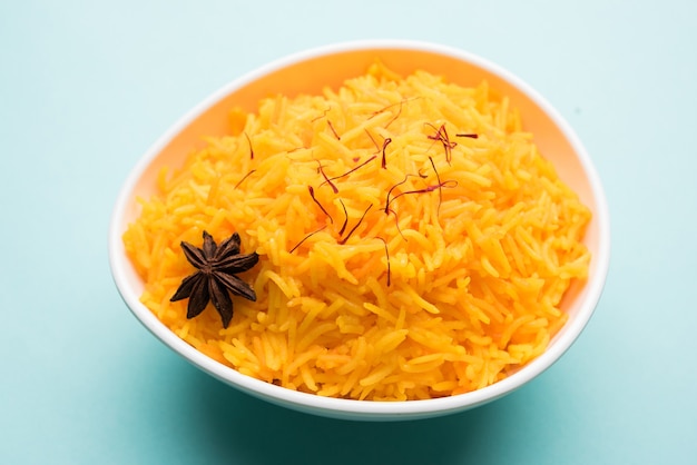 Arroz con azafrán o Kesar chawal o bhat, servido en un cuenco de cerámica blanca, enfoque selectivo