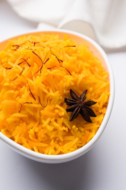 Arroz con azafrán o Kesar chawal o bhat, servido en un cuenco de cerámica blanca, enfoque selectivo