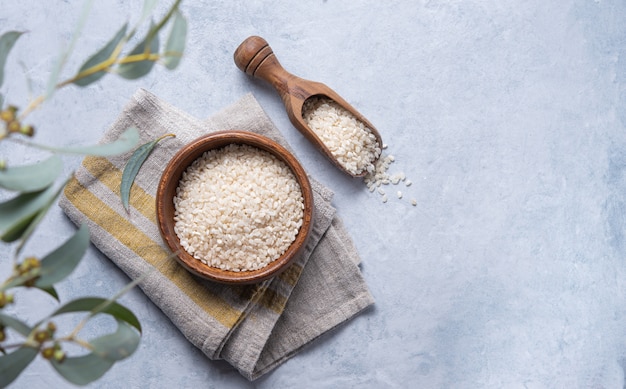 Arroz blanco Arborio en un tazón de madera sobre una servilleta