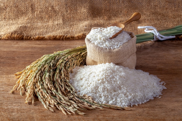 Arroz blanco (arroz jazmín) en un saco sobre un fondo de madera