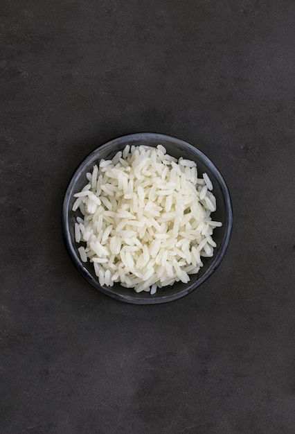 Arroz blanco cocido servido en plato negro