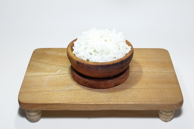 arroz blanco en un cuenco de madera sobre un fondo blanco