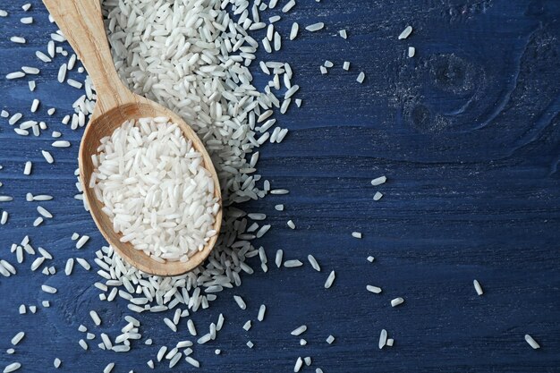 Arroz blanco de grano largo en cuchara sobre fondo de madera azul