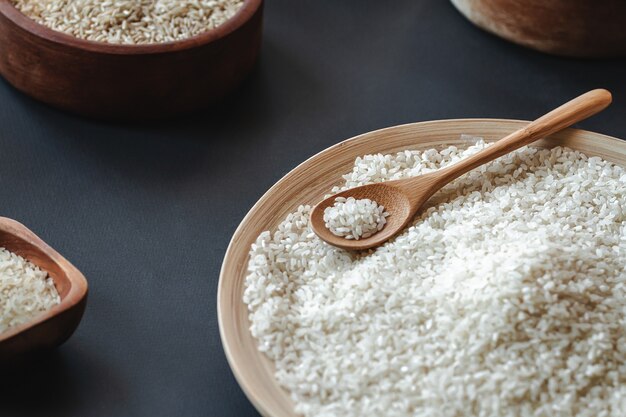 Arroz blanco redondo y cereales en cuchara de madera o bambú