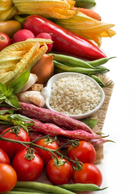 Arroz blanco en un tazón y verduras crudas frescas