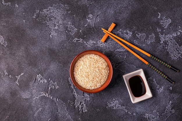 Arroz en un bol y palillos de madera