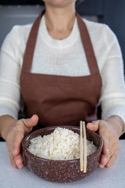 Arroz branco em tigela no foco seletivo de fundo branco