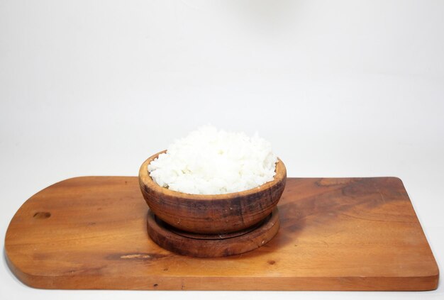 arroz branco em uma tigela de madeira sobre um fundo branco