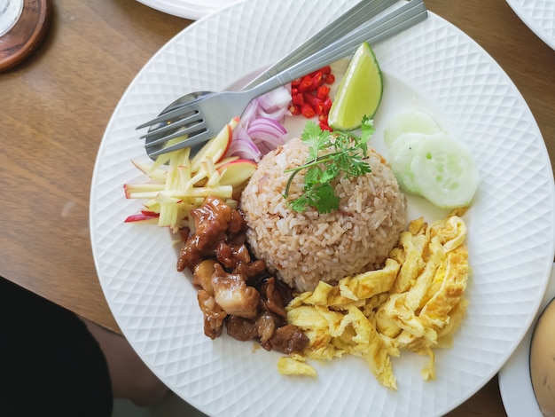 Arroz con carne de cerdo y huevo de fuego en la mesa de madera