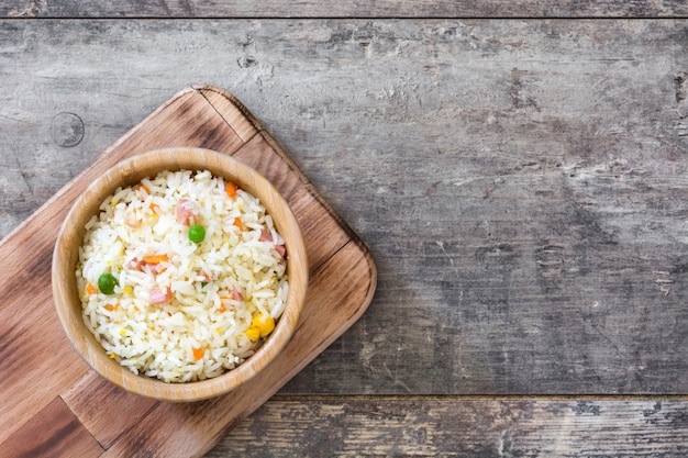 Arroz chinês frito com legumes na vista superior de madeira