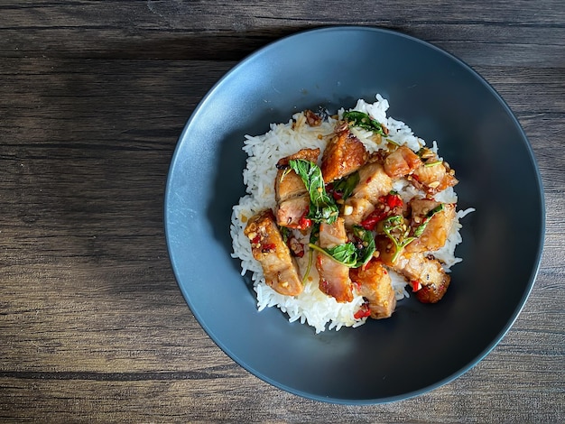 Arroz coberto com barriga de porco crocante com manjericão tailandês