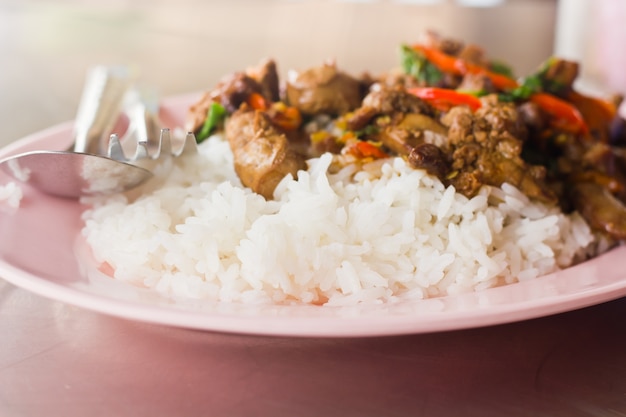 Foto arroz coberto com carne fritada e manjericão.