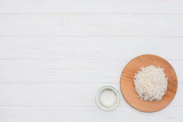 Foto arroz cocido sobre tabla de madera con agua.