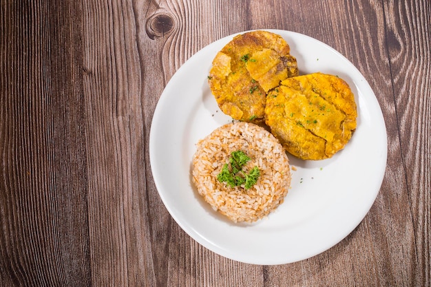 Arroz con coco y patacón de plátano macho y patacón en plato