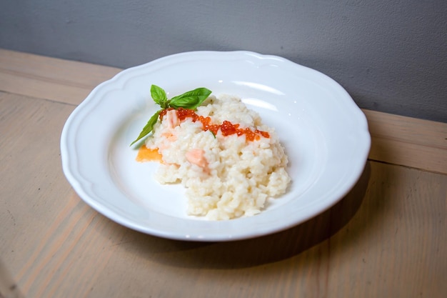 Arroz com caviar vermelho e salmão. Prato apetitoso no restaurante. Foto de alta qualidade