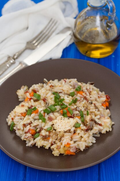 Foto arroz com frango e legumes no prato marrom