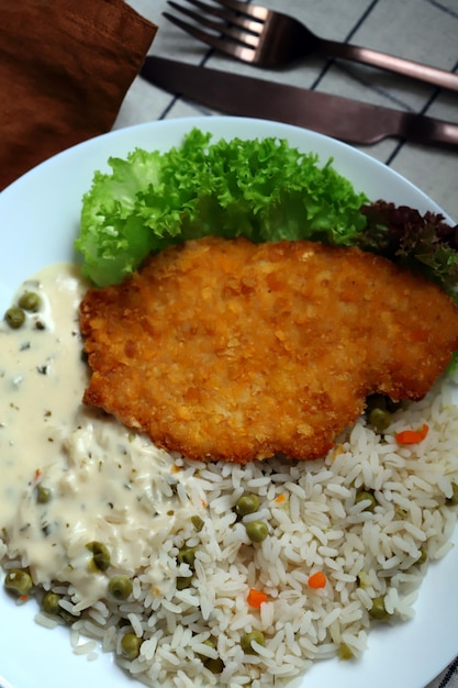 Arroz com legumes e schnitzel de frango Almoço ou jantar saudável num prato