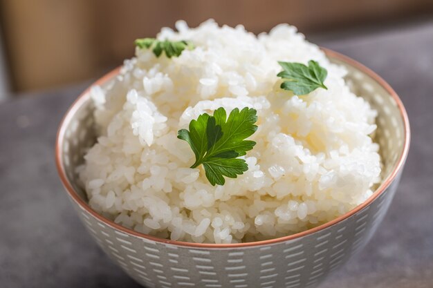 Arroz cozido em uma tigela na mesa da cozinha - close-up.