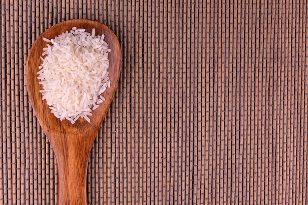 Arroz cru em uma colher de pau Copie o espaço