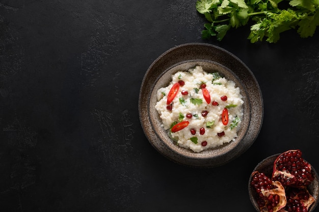 Arroz con cuajada de granada, semillas de mostaza, cilantro, jengibre sobre un fondo negro, cocina india