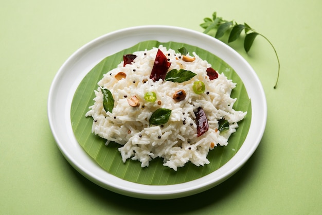 Arroz con cuajada o Dahi Bhat O Chawal con hoja de curry, maní y chile. Servido en un cuenco sobre un fondo de mal humor. Enfoque selectivo