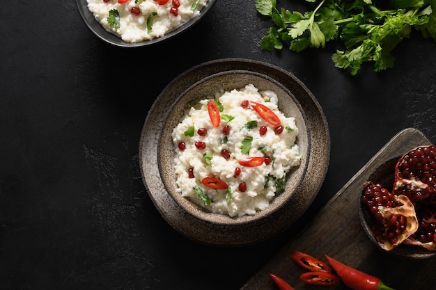 Arroz cuajado con granada, cilantro, semillas de mostaza, jengibre sobre un fondo negro, cocina india