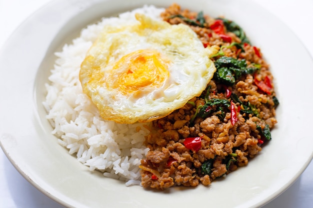 Arroz cubierto con cerdo salteado con albahaca y huevo frito