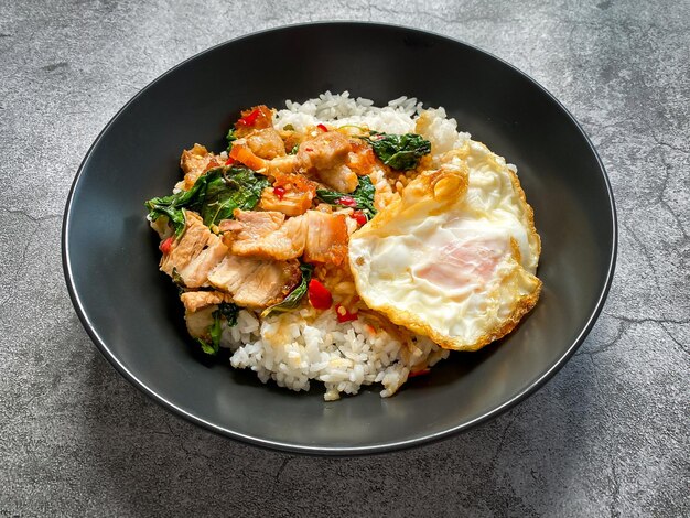 Arroz cubierto de pan de cerdo crujiente con albahaca tailandesa y huevo frito