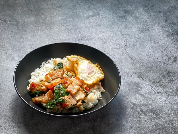 Arroz cubierto de pan de cerdo crujiente con albahaca tailandesa y huevo frito