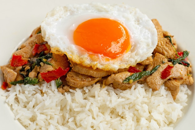 Arroz cubierto con pollo salteado y albahaca sagrada