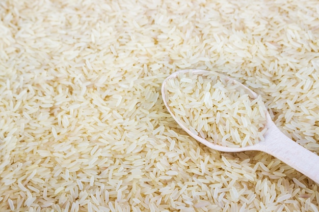 Arroz en una cuchara de madera. cerca de cereal de arroz