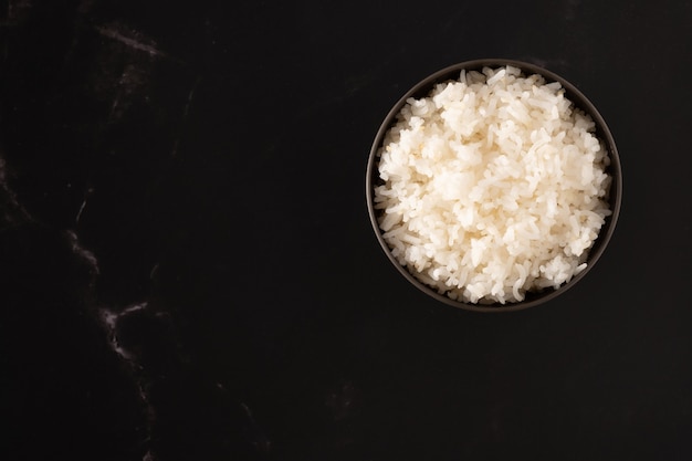 El arroz se cuece en un vaso de plástico sobre un fondo oscuro.