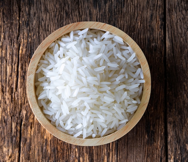 Arroz en cuenco de madera sobre mesa de madera