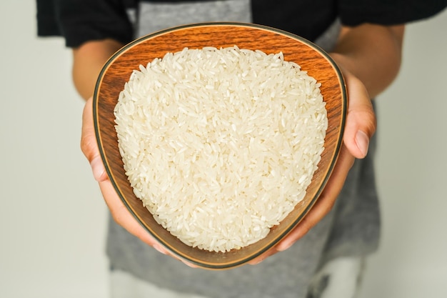 arroz en un cuenco de madera sostenido por la mano concepto de zakat