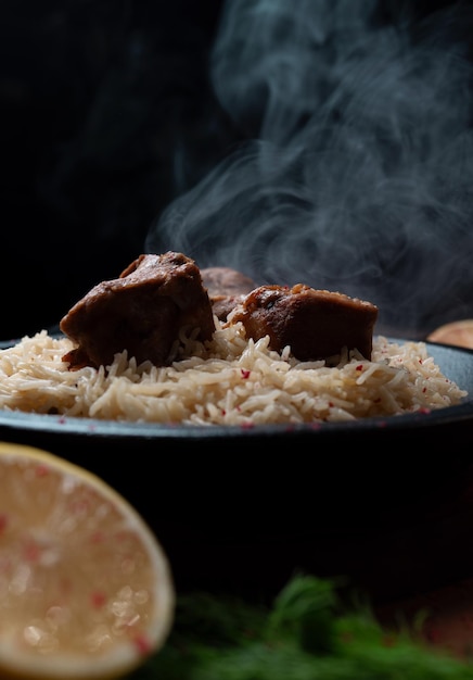 Arroz de carne É trazido e servido em um prato de pedra vista frontal