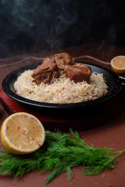 Arroz de carne É trazido e servido em um prato de pedra vista frontal