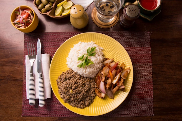 Arroz de frango salteado de lentilhas comida tradicional peruana mise en place mesa de madeira