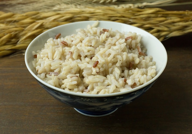 Arroz de jasmim cozido, arroz integral em tigela na mesa de madeira.